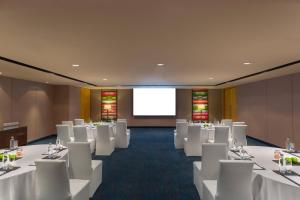 una sala de conferencias con mesas blancas y sillas blancas en Fairfield by Marriott Bengaluru Rajajinagar, en Bangalore