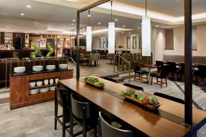 un restaurante con mesas y sillas y un bar en Marriott Cincinnati Airport, en Hebron