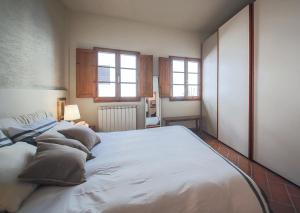 ein großes weißes Bett in einem Zimmer mit Fenstern in der Unterkunft Apartments Florence San Niccolò terrace in Florenz