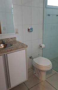 a bathroom with a white toilet and a sink at Ap em Capão da Canoa in Capão da Canoa +5 photos