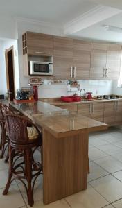 a kitchen with a large island with chairs in it at Ap em Capão da Canoa in Capão da Canoa