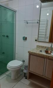 a bathroom with a toilet and a shower and a sink at Ap em Capão da Canoa in Capão da Canoa