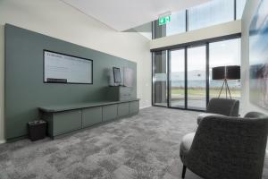 a waiting room with two chairs and a tv and windows at b-smart motel Schaan in Schaan