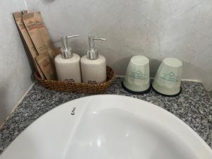 a bathroom counter with two soap dispensers and a sink at XUÂN HUỲNH 3 Hotel in Soc Trang