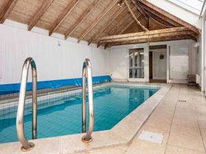 an indoor swimming pool with blue tiles in a building at 12 person holiday home in Hvide Sande in Havrvig