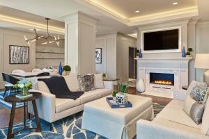 a living room with white furniture and a fireplace at The Hotel at Avalon, Autograph Collection in Alpharetta