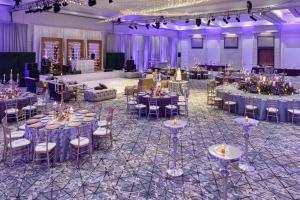 a banquet hall with tables and chairs and purple lighting at The Hotel at Avalon, Autograph Collection in Alpharetta