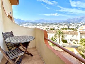 a table and chair on a balcony with a view at Albir Hills Apartments in Albir