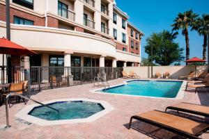 une piscine avec des chaises et un hôtel dans l'établissement Courtyard by Marriott Jacksonville I-295/East Beltway, à Jacksonville