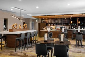 a restaurant with tables and chairs and a bar at Courtyard by Marriott Jacksonville I-295/East Beltway in Jacksonville