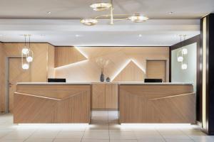 a lobby with a reception desk with wood panels at Courtyard by Marriott Wiesbaden-Nordenstadt in Wiesbaden