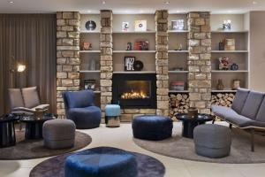 a lobby with chairs and a fireplace at Courtyard by Marriott Wiesbaden-Nordenstadt in Wiesbaden