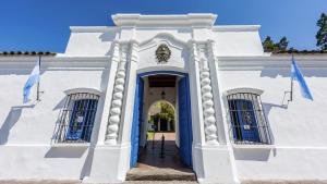 un edificio blanco con una puerta azul y dos banderas en Zafiro Barrio Norte by Citrino Aparts en San Miguel de Tucumán