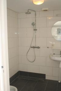 La salle de bains est pourvue d'une douche et d'un lavabo. dans l'établissement Appartement Tjerk, à Hollum