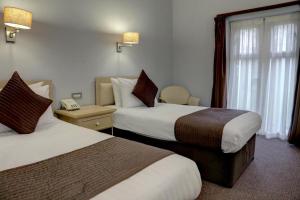 ソリフルにあるThe Regency Hotelのベッド2台、電話が備わるホテルルームです。