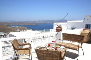 a table and chairs on a balcony with a view of the ocean at Mariakis Luxury Studios in Astypalaia