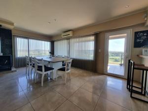 comedor con mesa, sillas y ventana en La Casa de los Vientos en Tandil