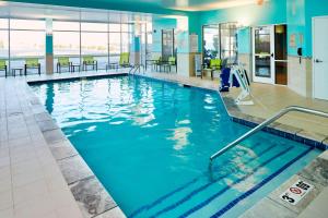 a swimming pool with blue water in a building at SpringHill Suites by Marriott Dayton Beavercreek in New Germany