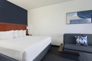 a hotel room with a bed and a couch at Courtyard Austin Airport in Austin +23 photos