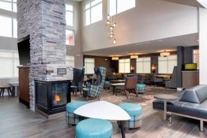 - un hall avec une cheminée, des tables et des chaises dans l'établissement Residence Inn by Marriott Lafayette, à Lafayette