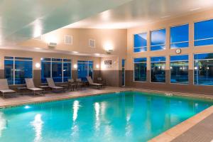 a swimming pool in a hotel with tables and chairs at Residence Inn by Marriott Lafayette in Lafayette