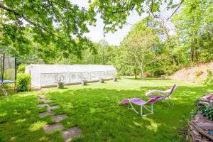 a yard with two chairs and a greenhouse at Gite des landes de la houssais in Guichen