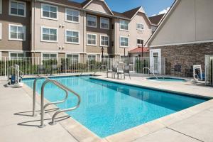 a swimming pool at a apartment complex with a building at Residence Inn Chico in Chico