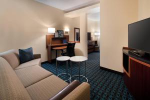 Habitación de hotel con sofá, TV y escritorio. en Fairfield Inn by Marriott Loveland Fort Collins en Loveland