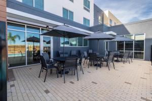 un patio con mesas, sillas y sombrillas en Fairfield Inn & Suites by Marriott Brownsville North, en Brownsville