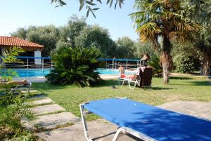 a blue ping pong table in front of a pool at Monemvasia Hotel in Skala Sotiros
