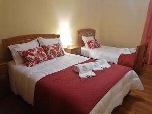 Dos camas en una habitación de hotel con toallas. en Casa de Maçaneira en Miranda do Douro