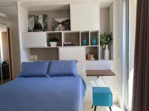 1 dormitorio con 1 cama azul y 1 silla azul en Incrível Apto DF Plaza com vista, en Brasilia