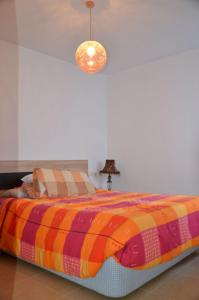 sypialnia z łóżkiem z kolorowym kocem w obiekcie FeWo - Moncofa Apartment w mieście Moncófar