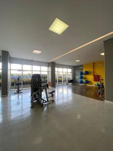 einen Fitnessraum mit Kardiogeräten in einem großen Raum mit Fenstern in der Unterkunft Incrível Apto DF Plaza com vista in Brasilia