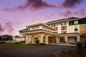 a large white building with a parking lot at Courtyard by Marriott Jekyll Island in Jekyll Island