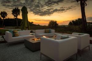 eine Gruppe weißer Sofas und eine Feuerstelle mit Schirm in der Unterkunft Courtyard by Marriott Jekyll Island in Jekyll Island