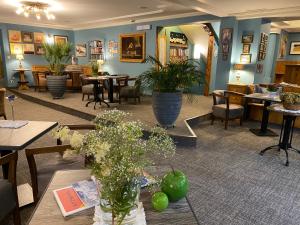 a restaurant with tables and chairs and plants at Hotel Edelweiss Kitzbühel in Kitzbühel