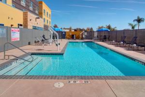 a swimming pool at a hotel with chairs and a building at Fairfield Inn & Suites by Marriott Bakersfield North/Airport in Bakersfield