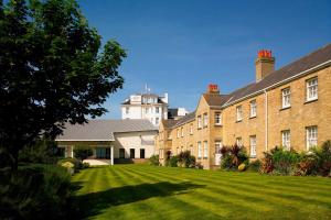 a large brick building with a large grass yard at Bournemouth Highcliff Marriott Hotel in Bournemouth