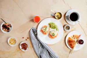 a table with plates of food and a cup of coffee at Bournemouth Highcliff Marriott Hotel in Bournemouth