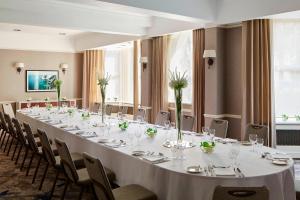a long table in a room with tables and chairs at Bournemouth Highcliff Marriott Hotel in Bournemouth