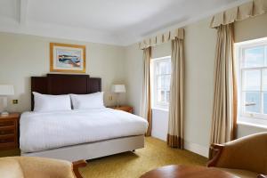 a hotel room with a bed and two windows at Bournemouth Highcliff Marriott Hotel in Bournemouth