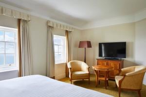 a hotel room with a bed and a flat screen tv at Bournemouth Highcliff Marriott Hotel in Bournemouth