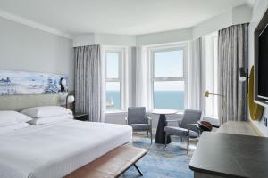 a hotel room with a bed and a table and chairs at Bournemouth Highcliff Marriott Hotel in Bournemouth