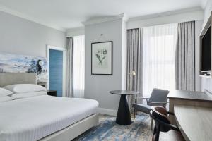 a hotel room with a bed and a desk and chair at Bournemouth Highcliff Marriott Hotel in Bournemouth