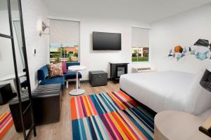 um quarto de hotel com uma cama e um tapete colorido em Aloft Dallas DFW Airport Grapevine em Coppell