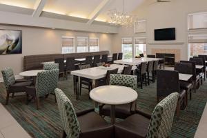 comedor con mesas y sillas y TV en Residence Inn Dallas DFW Airport North/Irving en Irving