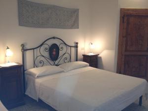 a bedroom with a bed and two night stands with lamps at B&B Codduecchju in Arzachena