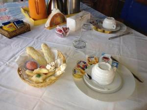 a table with a bowl of bread and a tea pot at B&B Codduecchju in Arzachena