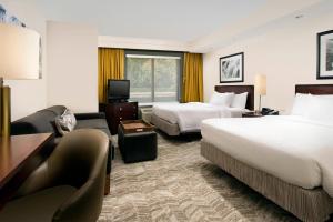 a hotel room with two beds and a couch at SpringHill Suites by Marriott Jacksonville North I-95 Area in Jacksonville